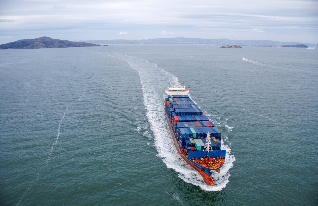 gallery-6 Aerial view of a large container ship sailing through open ocean waters.