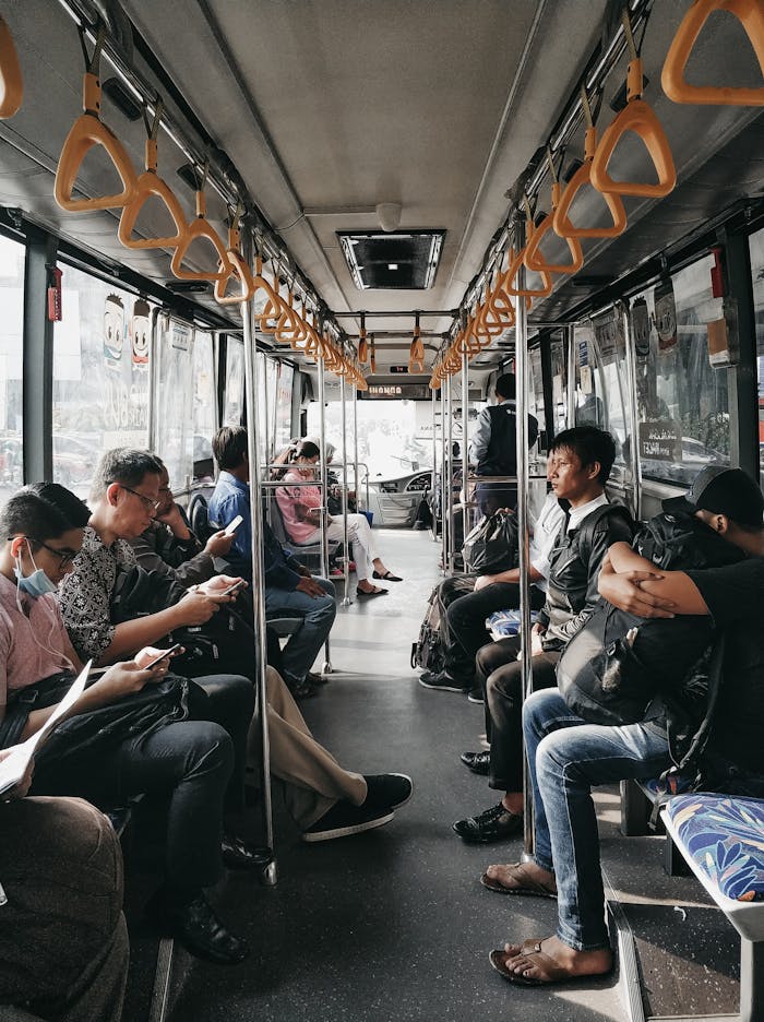gallery-2 Passengers occupy seats inside a city bus as it moves through an urban area, showcasing daily commute life.