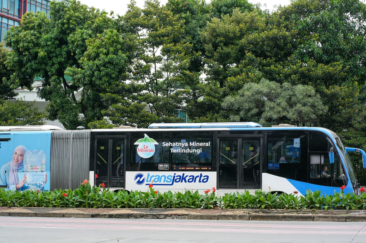 gallery-3 TransJakarta bus passing through a green urban park area with advertisement